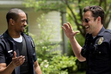 Damon Wayas Jr. y Jake Johnson en el cine durante una escena de 'Vamos de polis' (2014)