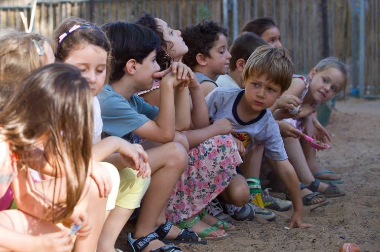Avi Shnaidman entre los niños de una escena