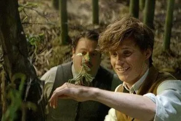 Eddie Redmayne y Dan Fogler con un personaje animado de la película